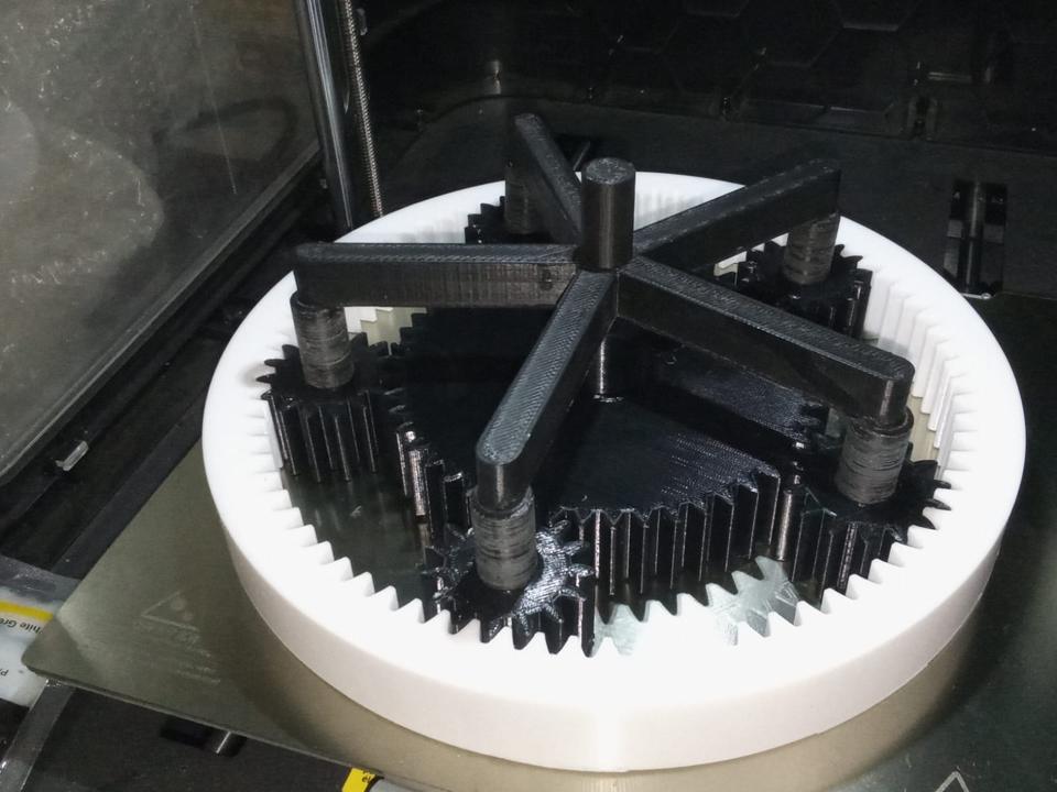 3D printed planetary gear set with black gears and a white ring